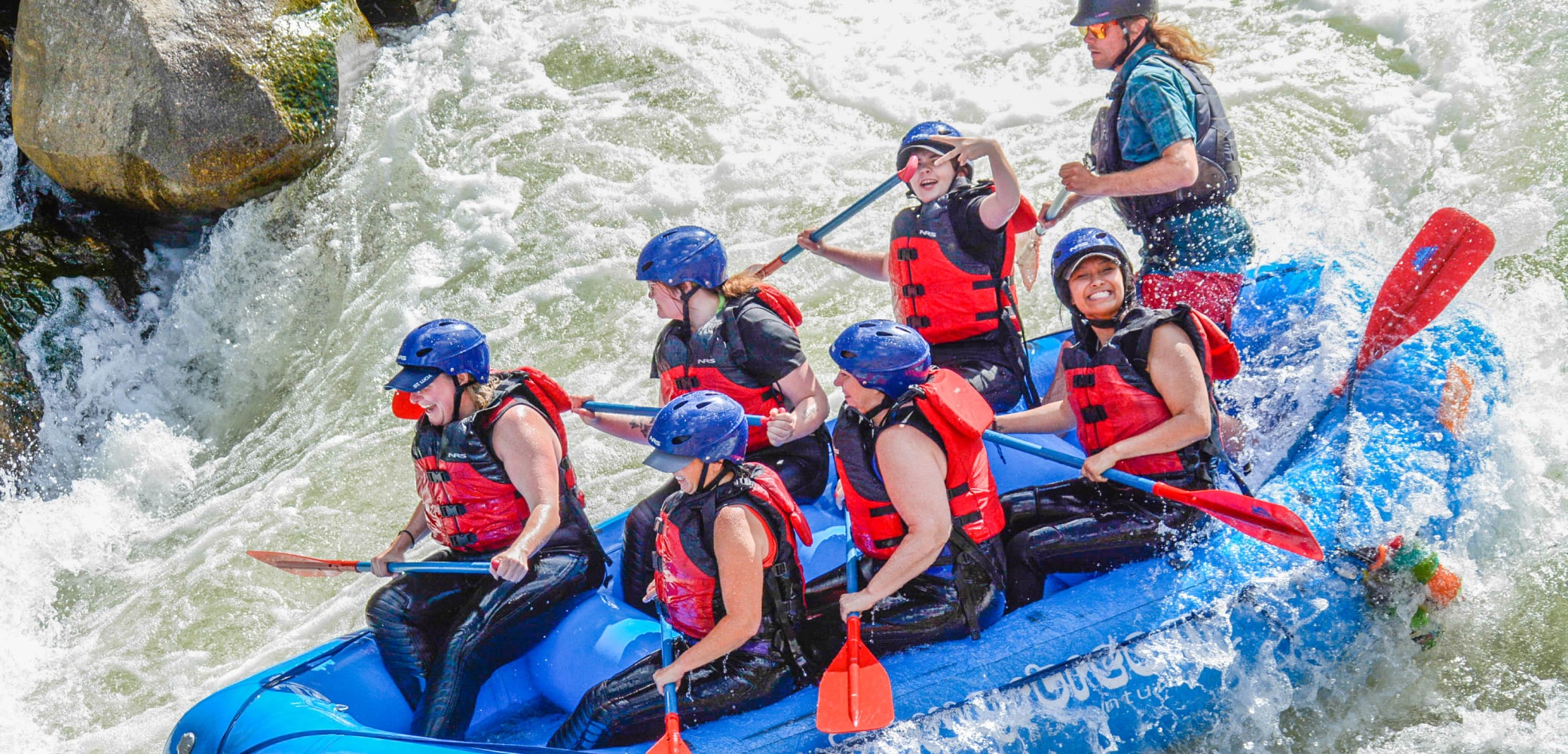 people smiling while navigating the rapids on clear creek rafting trip near denver