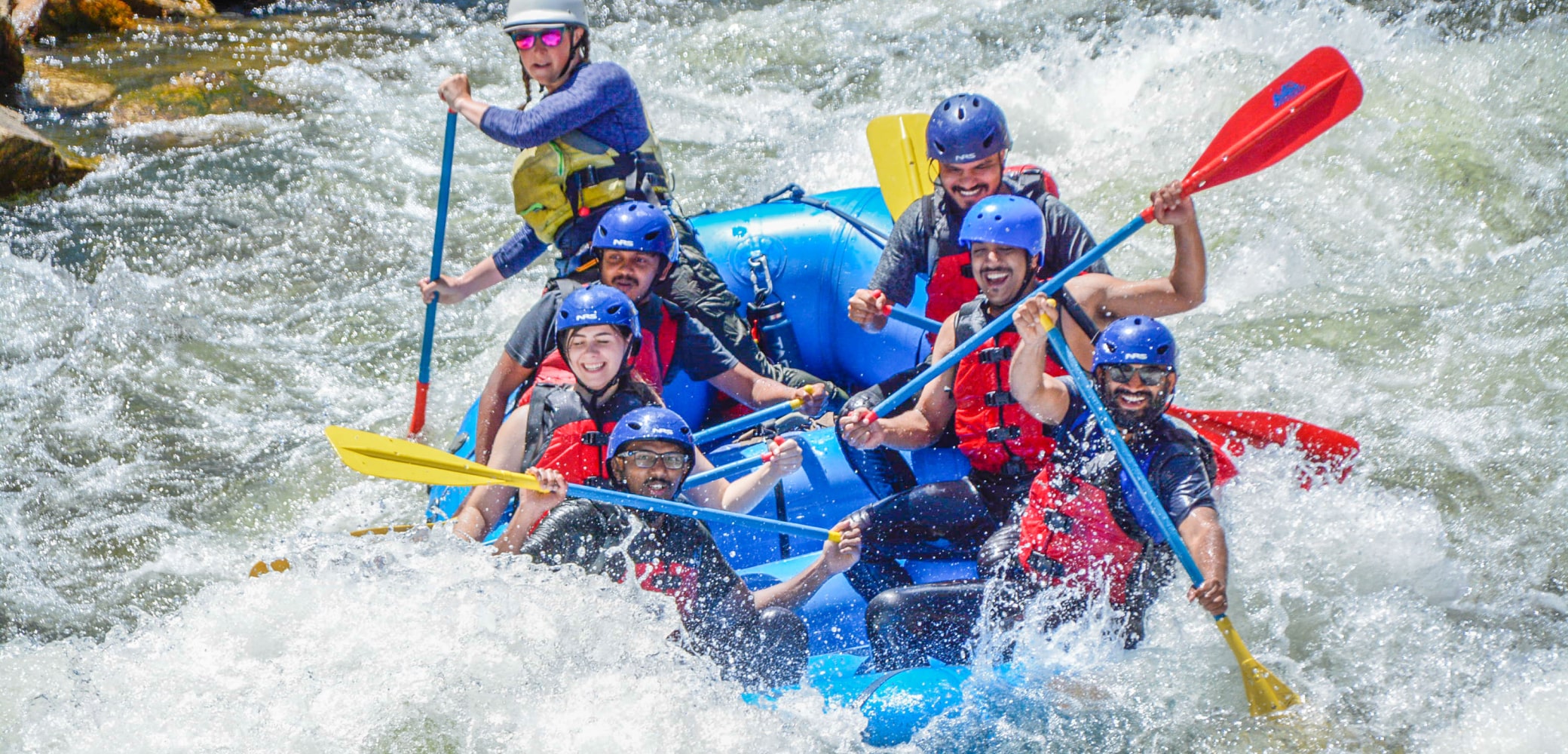 People smiling while navigating rapids on upper clear creek rafting trip