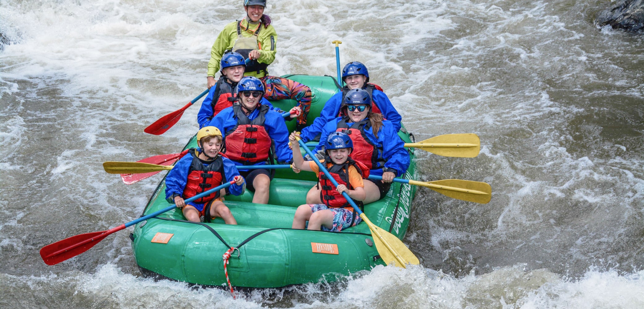People navigating rapids while white water rafting for beginners