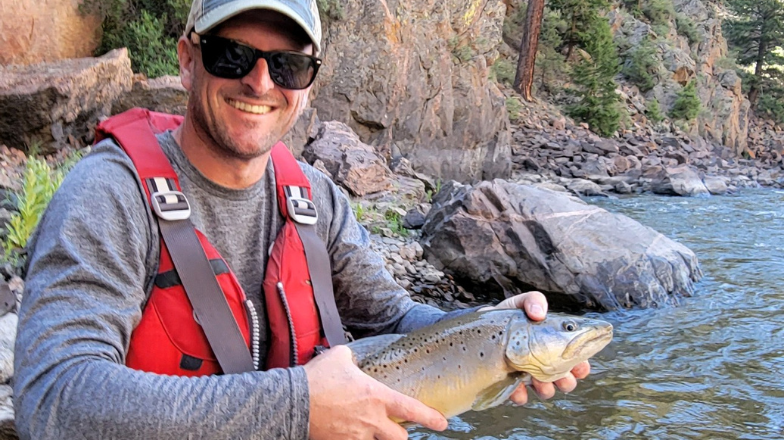 man holding fish on guided upper colorado float fishing trip