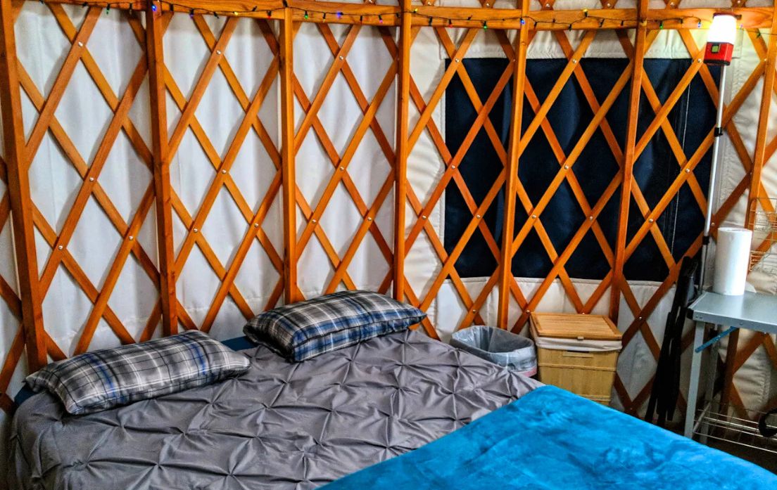 queen bed in bunkhouse style yurt for glamping near denver