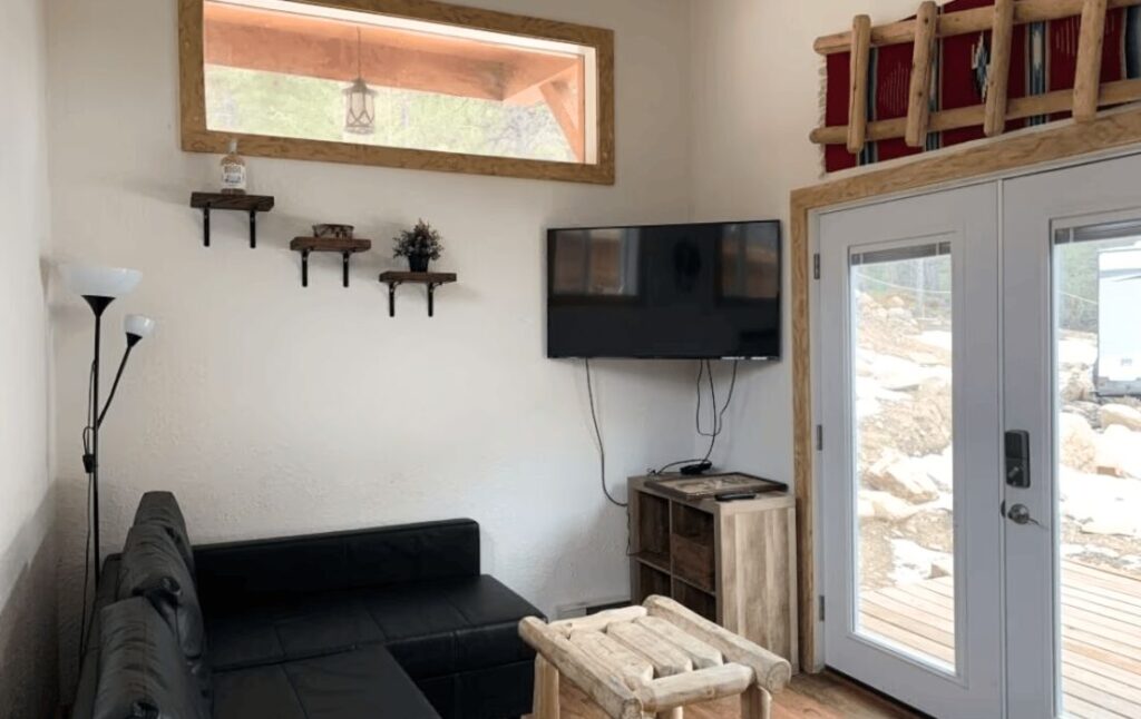 living room with TV and sliding glass door in our 2-bedroom cabin rental