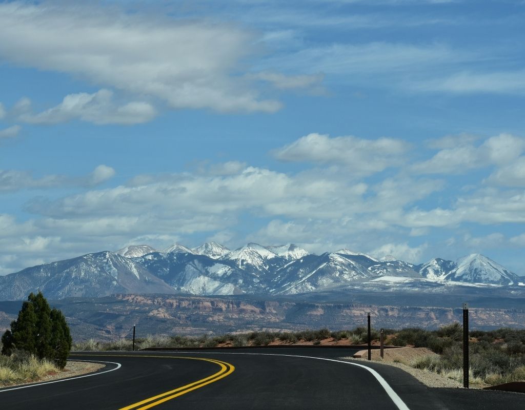 road in a valley with the Rocky Mountains in the background on the way to Denver whitewater rafting