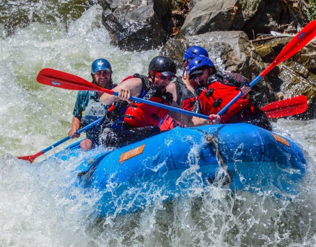 people in a blue raft on rapids while rafting Buena Vista Colorado