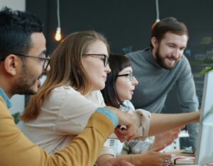 people in an office looking at a computer screen