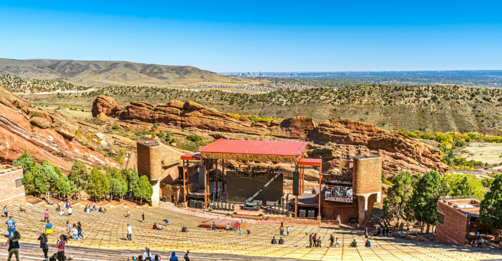 people on the bleachers at Red Rocks Amphitheatre with the desert behind